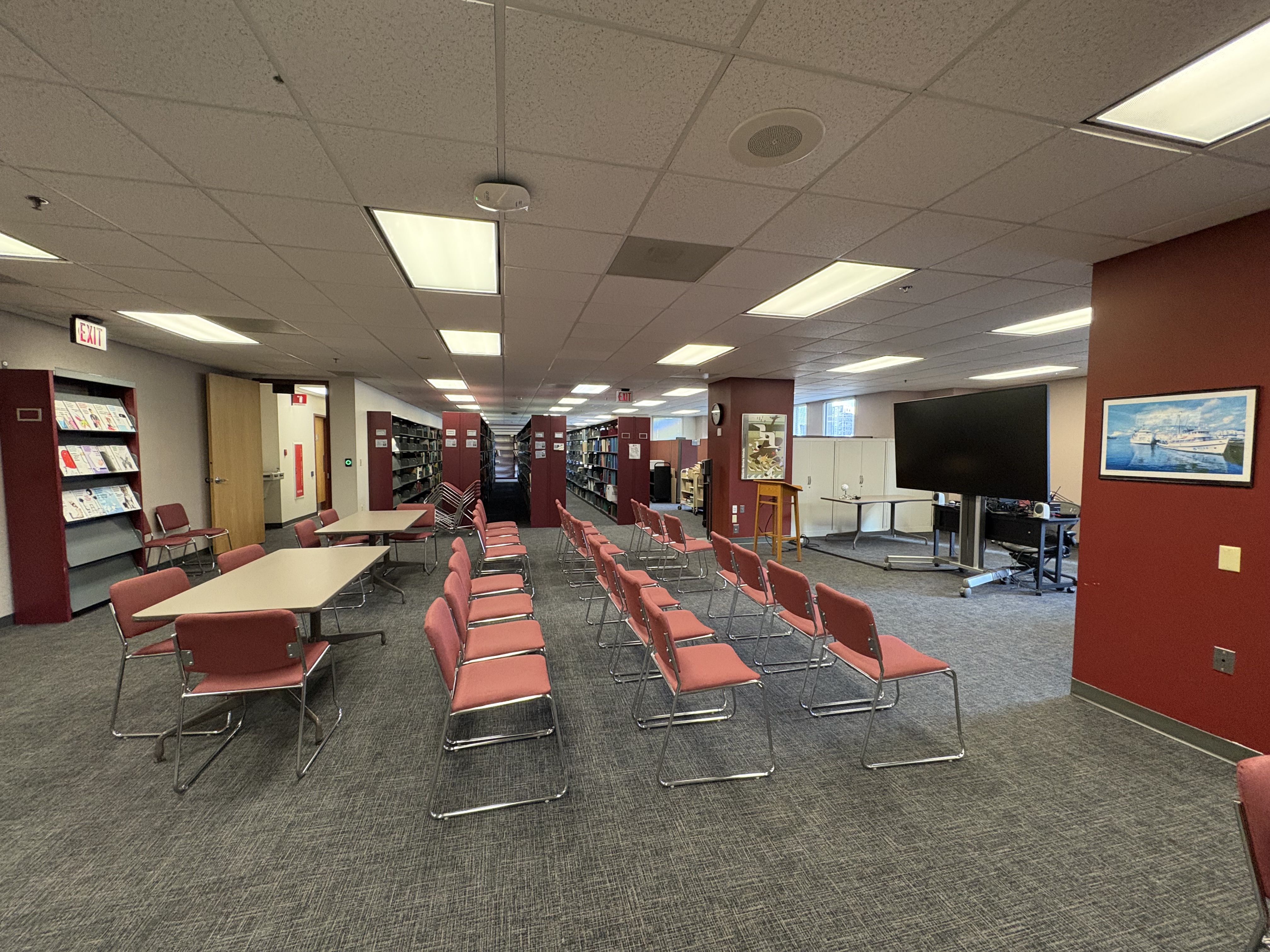Library space with chairs set up in rows in front of a tv screen.