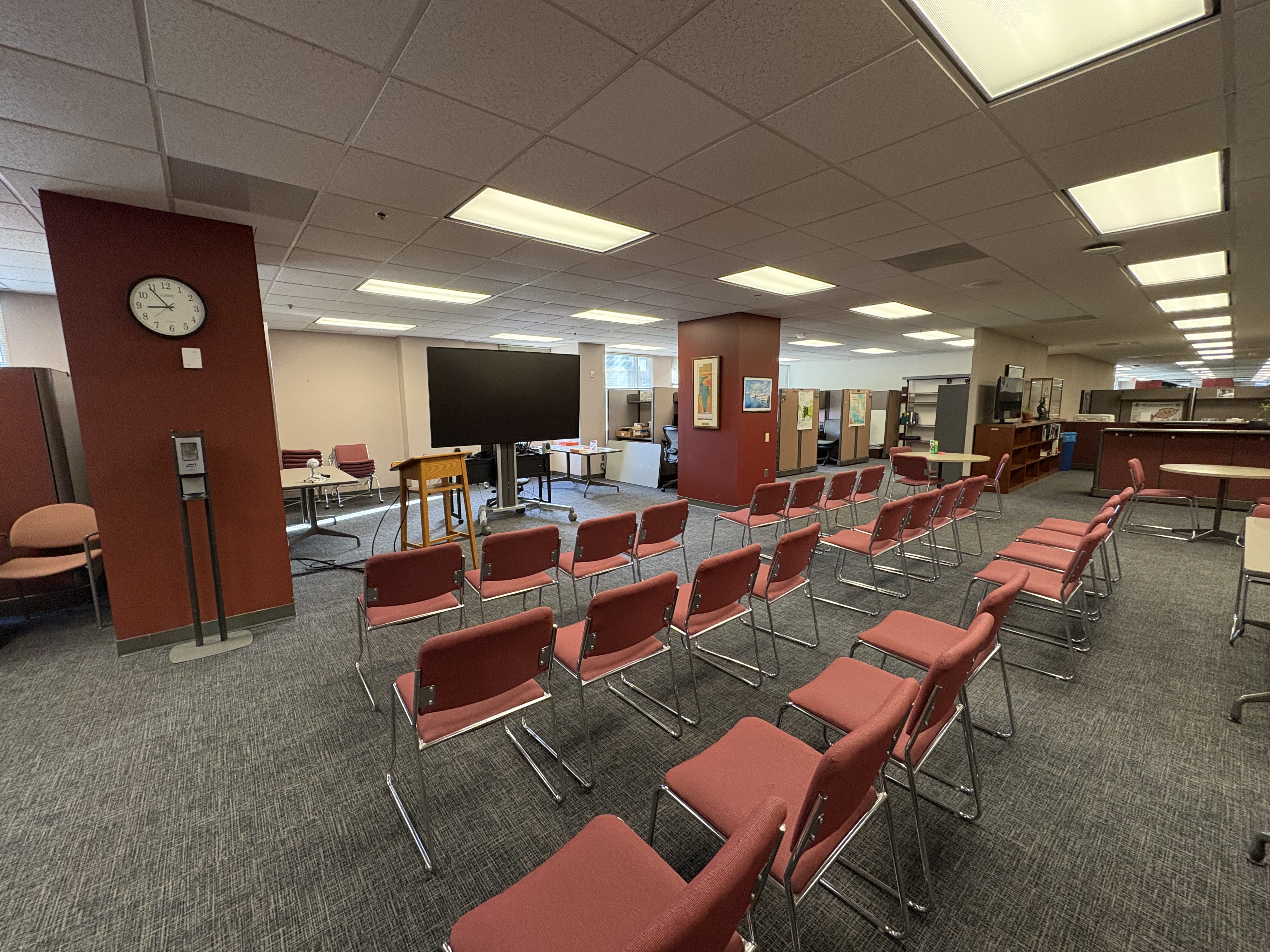 Library space with rows of chairs set up in front of a TV.
