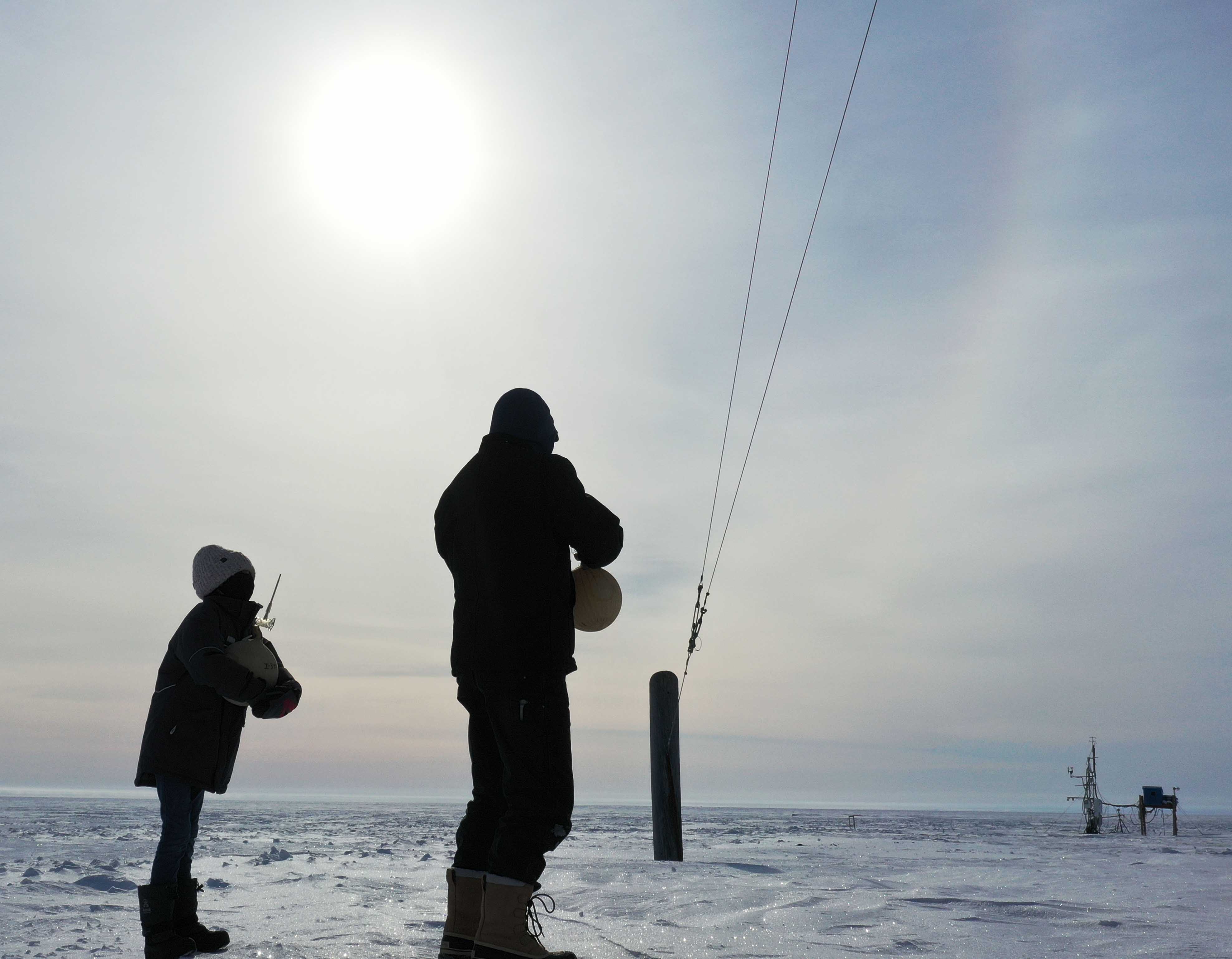 Bryan Thomas, Barrow station chief, and a local student capture air samples in glass flasks. The samples are analyzed at NOAA in Boulder, Colorado and at the University of Colorado Boulder.