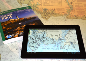 Coast Pilot book and tablet displaying nautical chart app
