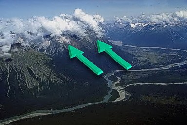 Clouds forming over mountain tops due to wind moving upslope and converging.