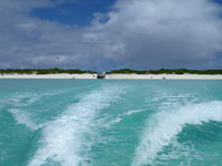 Boat wake moving away from beach