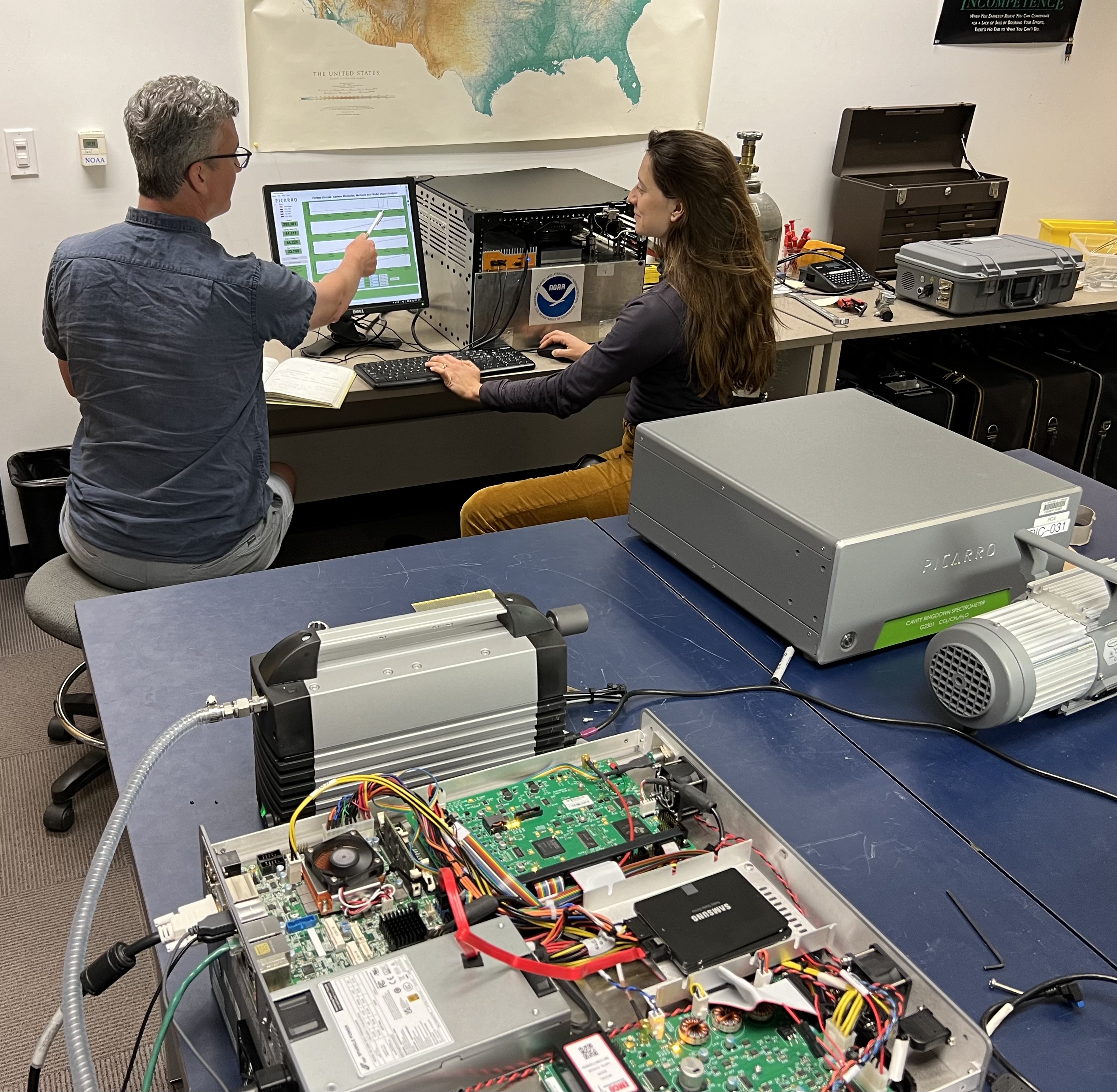 Photo of CIRES scientists Jeff Peischl (left) and Anna McAuliffe (right) prepare an instrument for deployment on an research aircraft for the NOGAP field project inside NOAA’s Global Monitoring Laboratory at the NOAA Boulder research center on July 19, 2024. Credit: Sonja Wolter/CIRES.