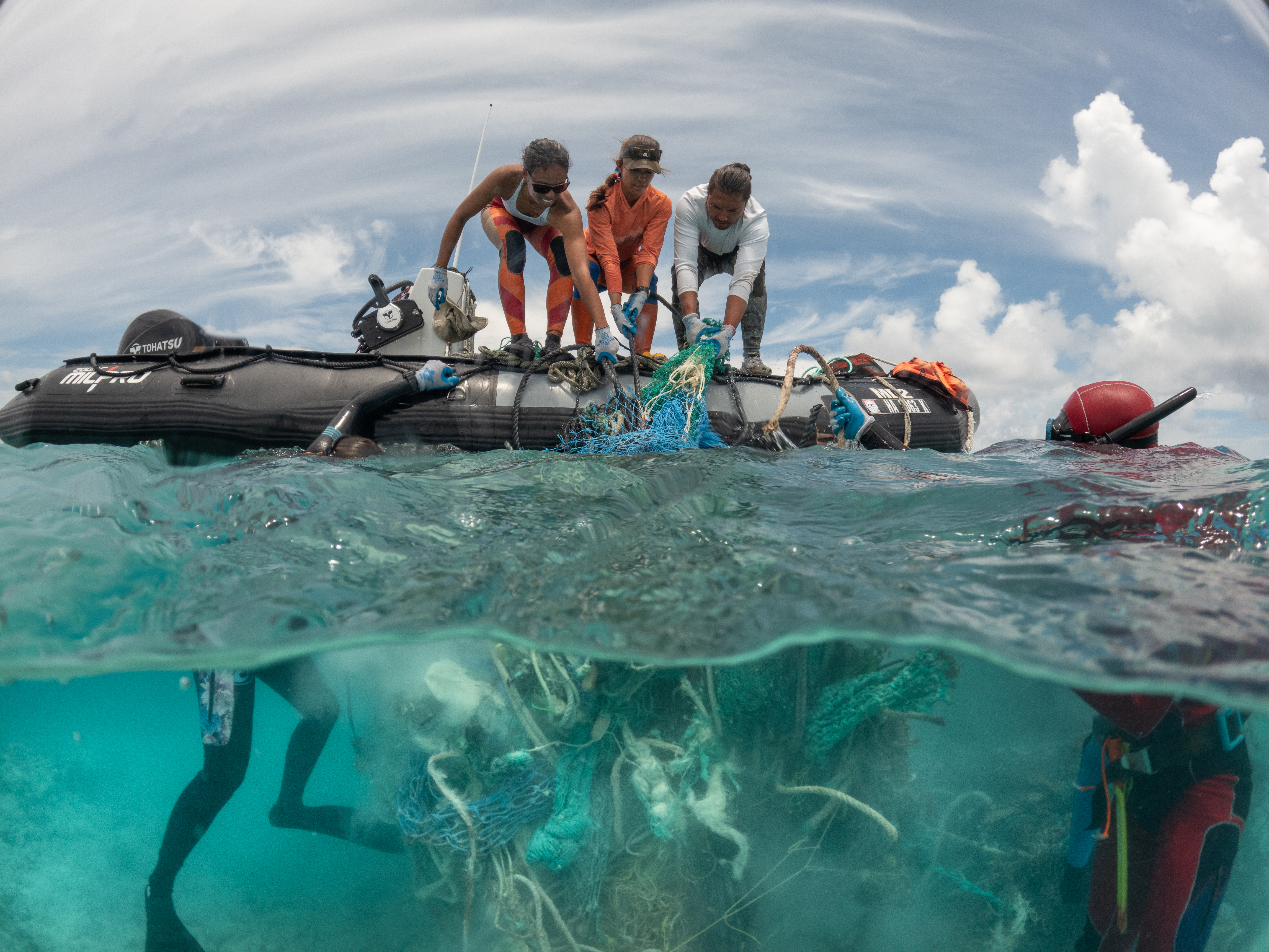 Teams from the Papahānaumokuākea Marine Debris Project (PMDP) in Hawaii work above and below the water at Kamokuokamohoaliʻi (Maro reef) to remove a large abandoned fishing net.