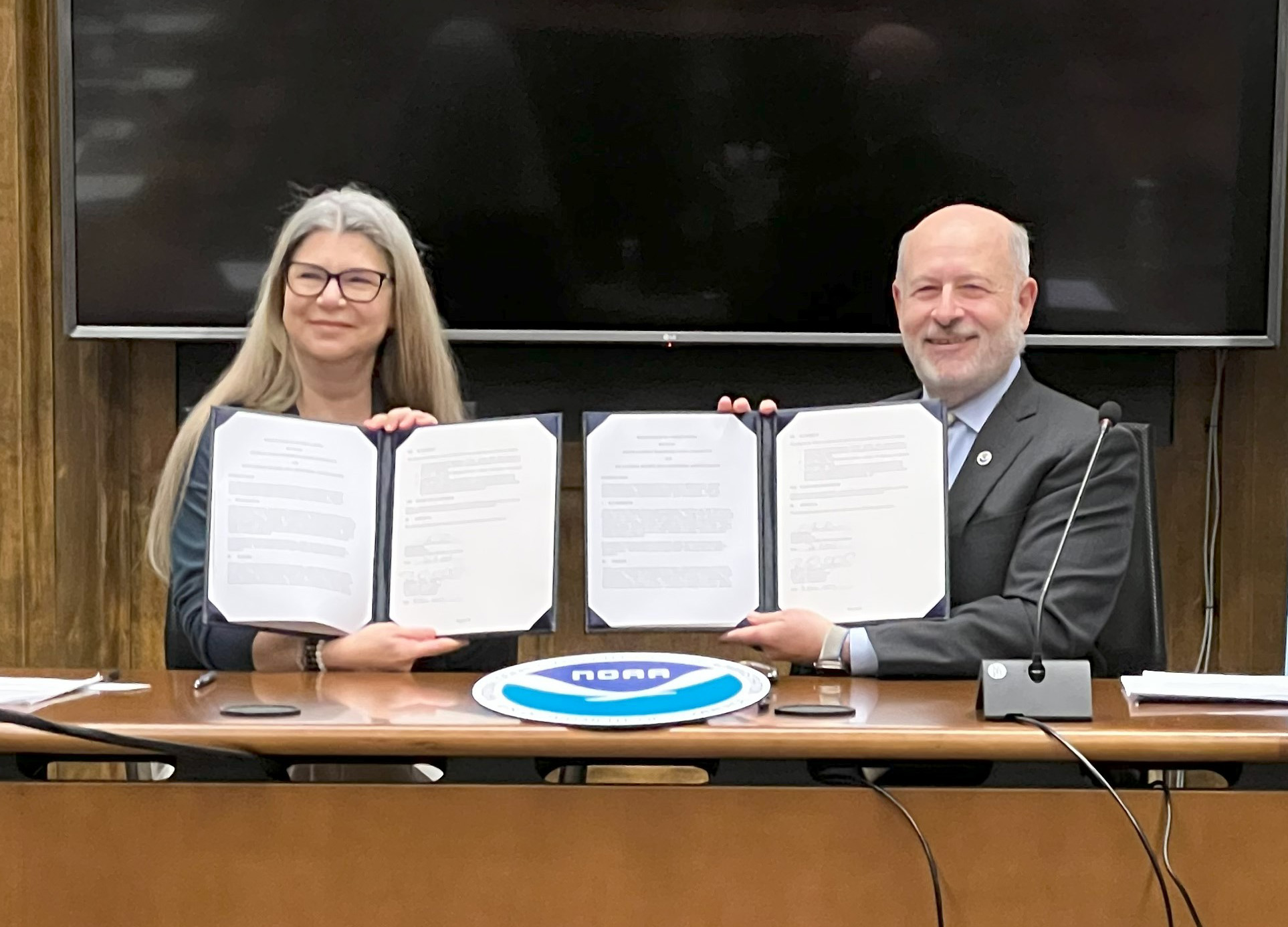 Photo showing Ahniwake Rose, President and CEO of the American Indian Higher Education Consortium, and Dr. Rick Spinrad, NOAA administrator, hold up the freshly signed Memorandum of Understanding outlining how NOAA and the consortium will work together to advance Indigenous Knowledge, science, technology, education and workforce training opportunities for tribal communities with the goal of building climate resilience. Credit: NOAA