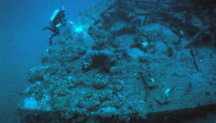A diver swims above the bow of the USS Monitor.