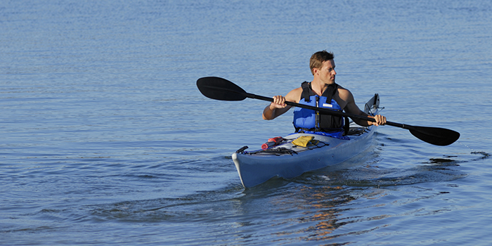 Kayaker wearing a life jacket while paddling.
