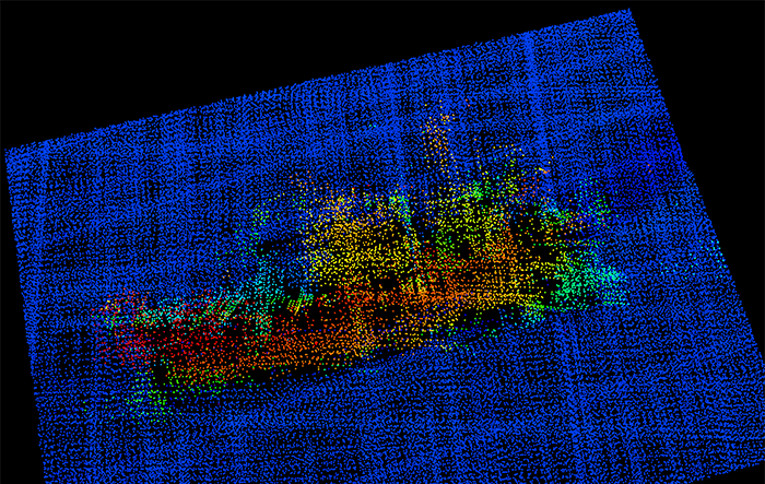 A 3-D image from NOAA Ship Fairweather multi-beam sonar. The profile of the F/V Destination is clearly visible, including the bulbous bow to the right, the forward house and mast, equipment (likely crab pots) stacked amidships, the deck crane aft, and the skeg and rudder. 
