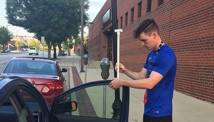 Luke Hanno, a high school senior from Bowie, Maryland, and citizen scientist mounts a special temperature sensor on his car just prior to driving his assigned route in Baltimore on Aug. 29, 2018.