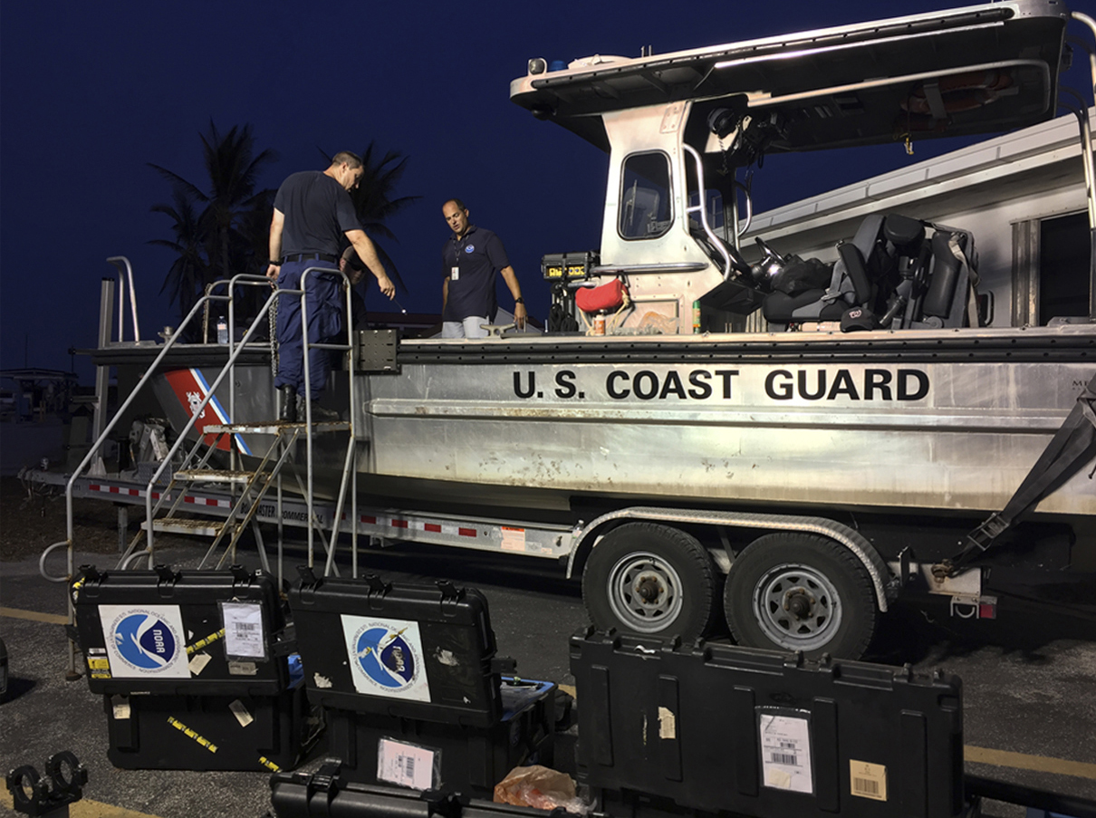 Mike Annis (right), NOAA scientist and lead of NOAA's Mobile Integrated Survey Team (MIST), and LCDR Jonathan French, NOAA Corps officer in charge of a NOAA Coast Survey Navigation Response Team, mount side scan sonar on a Coast Guard vessel in Key West.