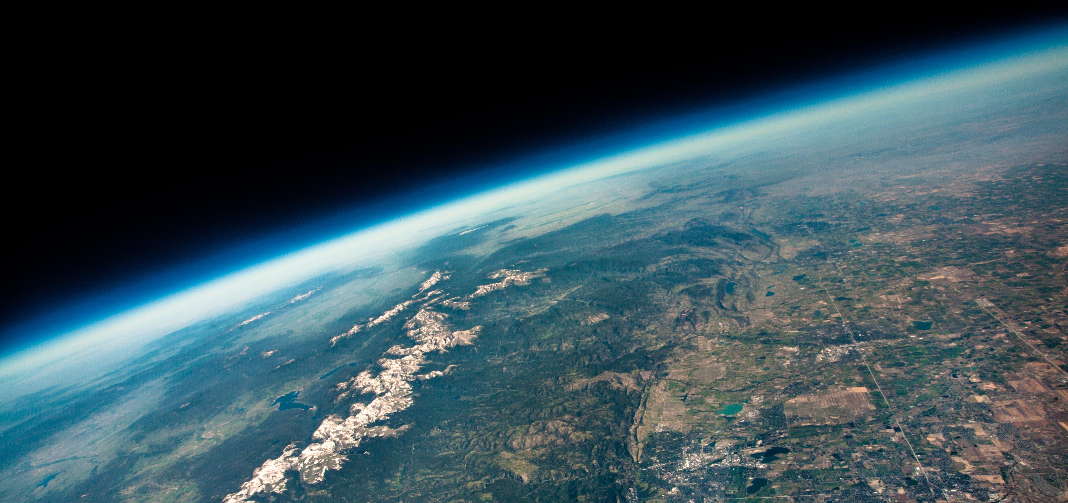 The view from an ozone balloon floating 100,000 feet above the Colorado Front Range. NOAA scientists based in Boulder, Colorado launch weekly balloons from sites all around the globe to monitor stratospheric ozone concentrations. Floating to over twice the altitude of commercial airliners, the curvature of Earth and inky black of space are clearly visible.