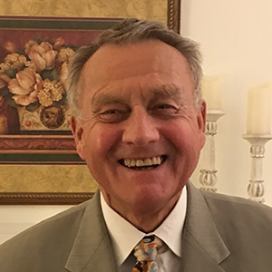 A photo of Jerrold Norton in a grey suit, looking at camera.