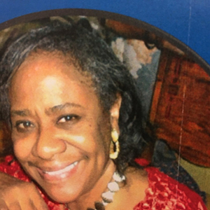 A photo of Sheila Styles in a red blouse, looking at camera.