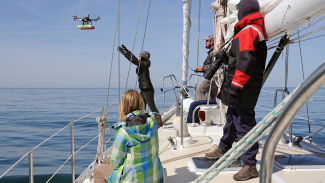 Unmanned aerial systems, such as the 'hexacopter' pictured above, are a powerful new tool for whale research. NOAA's John Durban, center, remotely directs the hexacopter into the outstretched hands of NOAA's Holly Fearnbach.