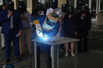 A welder from Thoma-Sea Marine Constructors, LLC, welds the initials of the Oceanographer's sponsor, Linda Kwok Schatz, onto a steel plate that will be incorporated into the ship in keeping with maritime tradition. 
