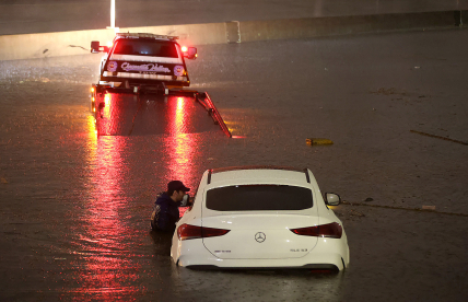 A tow truck driver attempts to pull a stranded car out of floodwaters on the Golden State Freeway as tropical storm Hilary moves through the area on August 20, 2023 in Sun Valley, California.