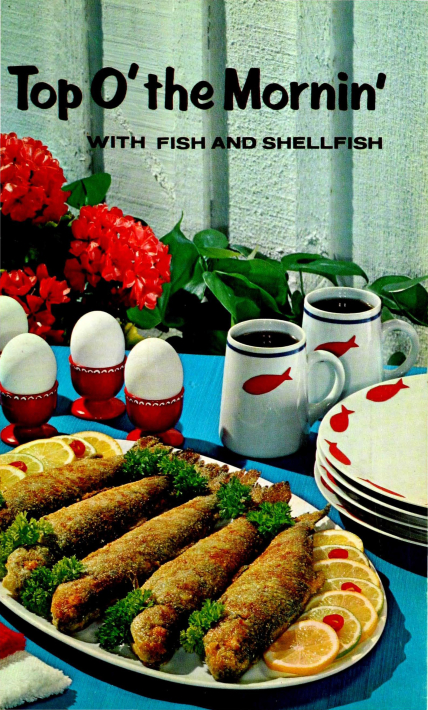 The front cover of Test Kitchen Series No. 15, from 1965. The title reads, "Top O' the Mornin' WITH FISH AND SHELLFISH" in black text and the cover shows a plate of garnished fish with eggs in red cups, and white mugs of coffee and stacked plates with red fish on them.