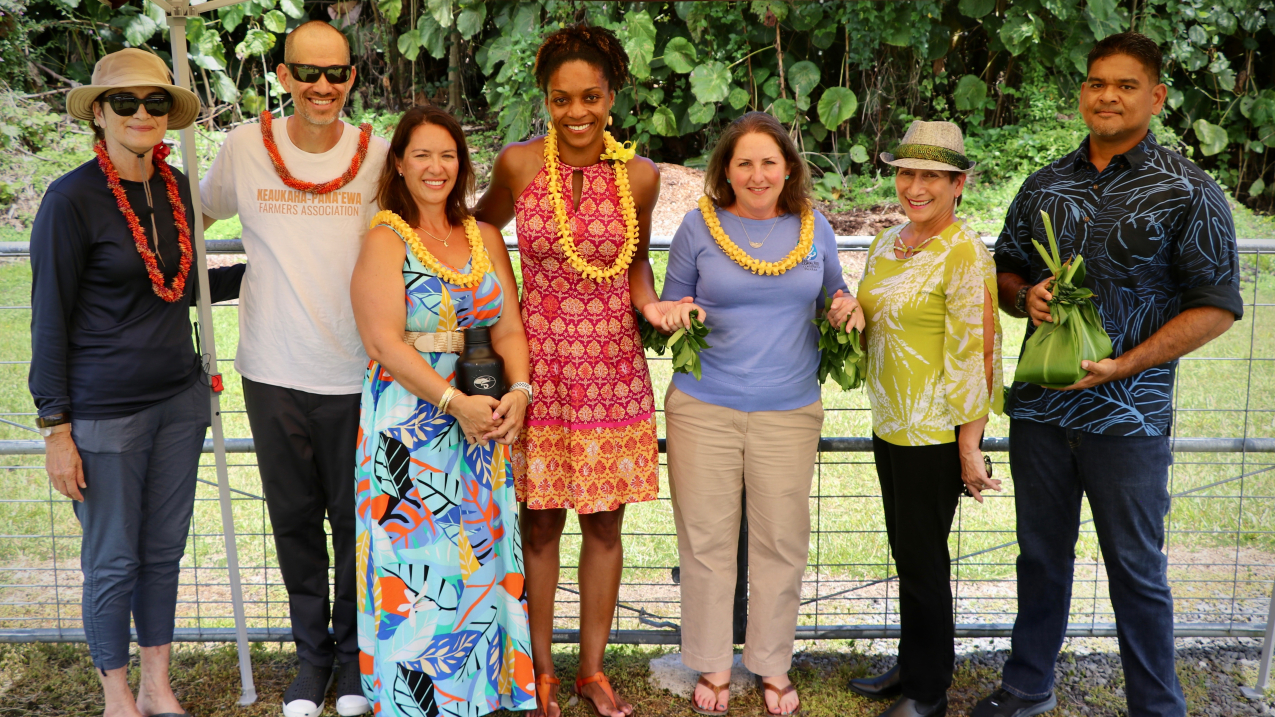 Photo showing Representatives from NOAA and Keaukaha Panaʻewa Farmers Association affirm partnership through site blessing of the pilot project. Pictured from left to right are: Nāmaka Rawlins (Panaʻewa homesteader), Makaʻala Rawlins (Keaukaha Panaʻewa Farmers Association member), Pua Kamaka (NOAA Pacific Islands Coordinator), Letise LaFeir (NOAA Senior Advisor), Nicole LeBoeuf (Assistant Administrator for NOAA’s National Ocean Service), Maile Luʻuwai (President of Keaukaha Panaʻewa Farmers Association) and