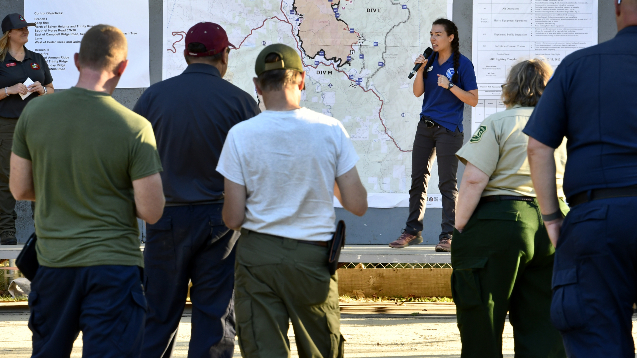 IMET trainee Rebecca Muessle provides an update on weather conditions to fire crews at Six Rivers Lightning Fire in Northern California on August 23, 2022. Credit: Robert Hyatt, NOAA’s National Weather Service.