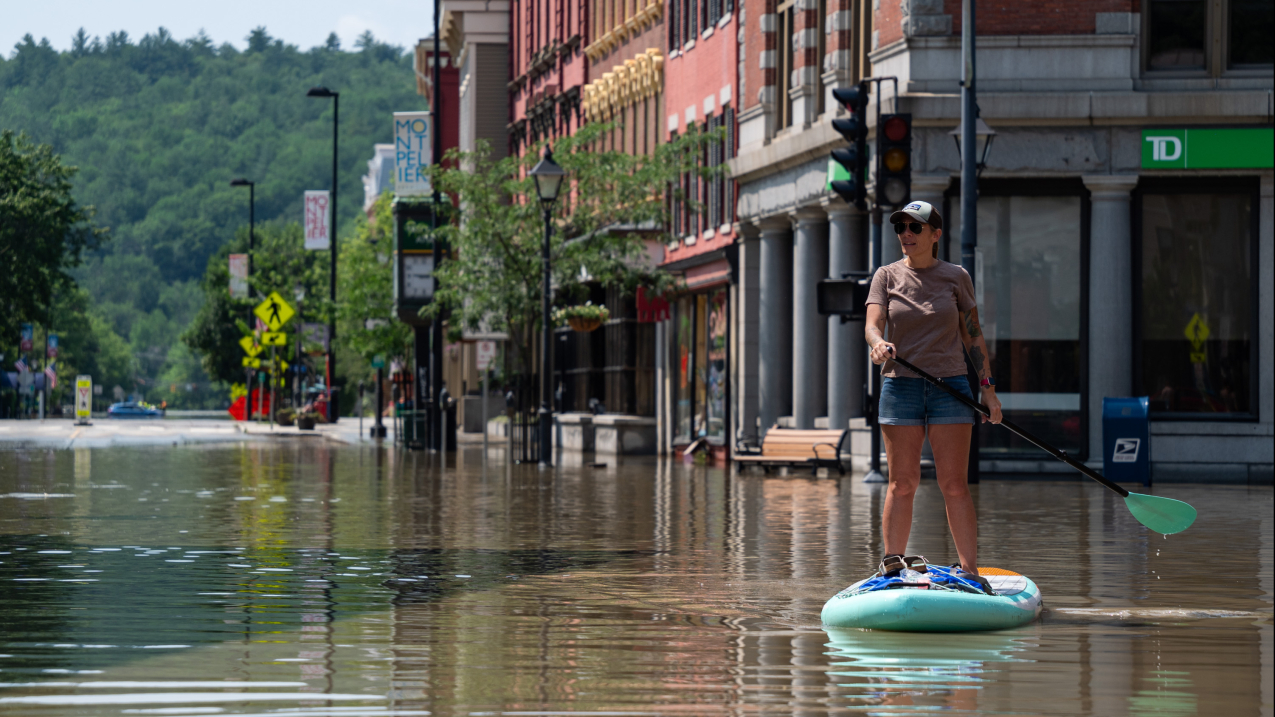 Montpelier resident Lynnea Timpone paddle boards at the intersection of Main Street and East State Street on July 11, 2023, in Montpelier, Vermont. Up to 8 inches of rain fell over 48 hours, causing catastrophic flooding in the area. 