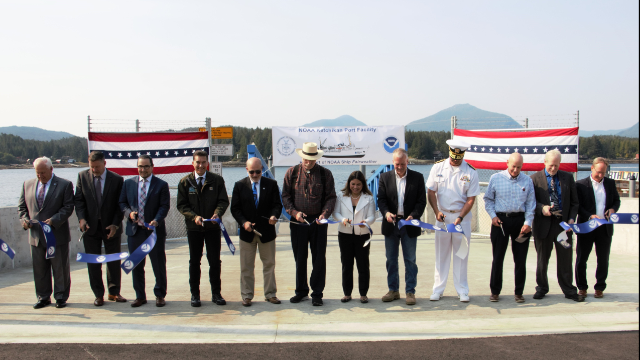A long line of special guests, including NOAA Administrator Dr. Rick Spinrad (5th from the left), participate in a ribbon-cutting ceremony for the NOAA-renovated port facility in Ketchikan, Alaska, on August 21, 2023.