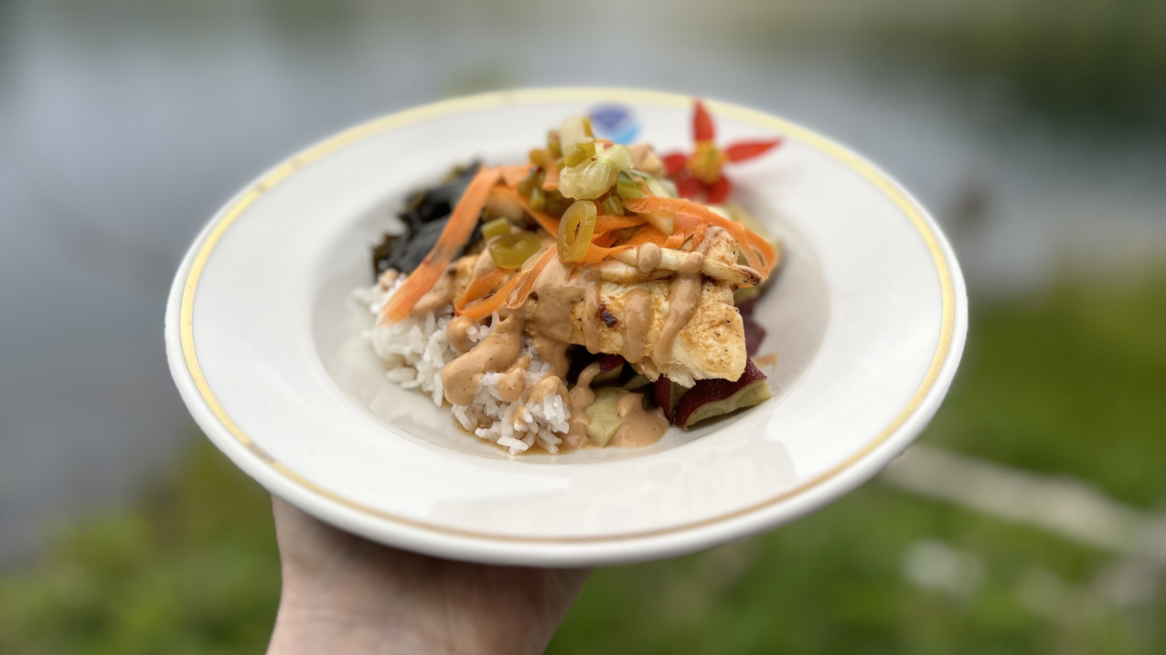 A close-up photo of a meal that looks professionally made and plated in a shallow bowl with a gold rim and NOAA logo.