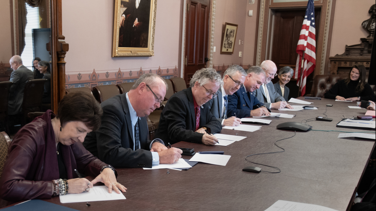 Photo showing Signing of the Memorandum of Agreement for Space Weather Research-to-Operations-to-Research Collaboration, Eisenhower Executive Office Building, Washington, D.C., Dec. 7, 2023. Left to right: NASA Nicola Fox, Ph.D., NOAA Ken Graham, NOAA Stephen Volz, Ph.D., NSF Timothy Patten, Ph.D. (on behalf of Alexandra Isern, Ph.D.), DAF Major General Mark Slocum (on behalf of Lieutenant General James C. Slife), and DAF Dr Joel Mozer (on behalf of Lisa Costa, Ph.D.).