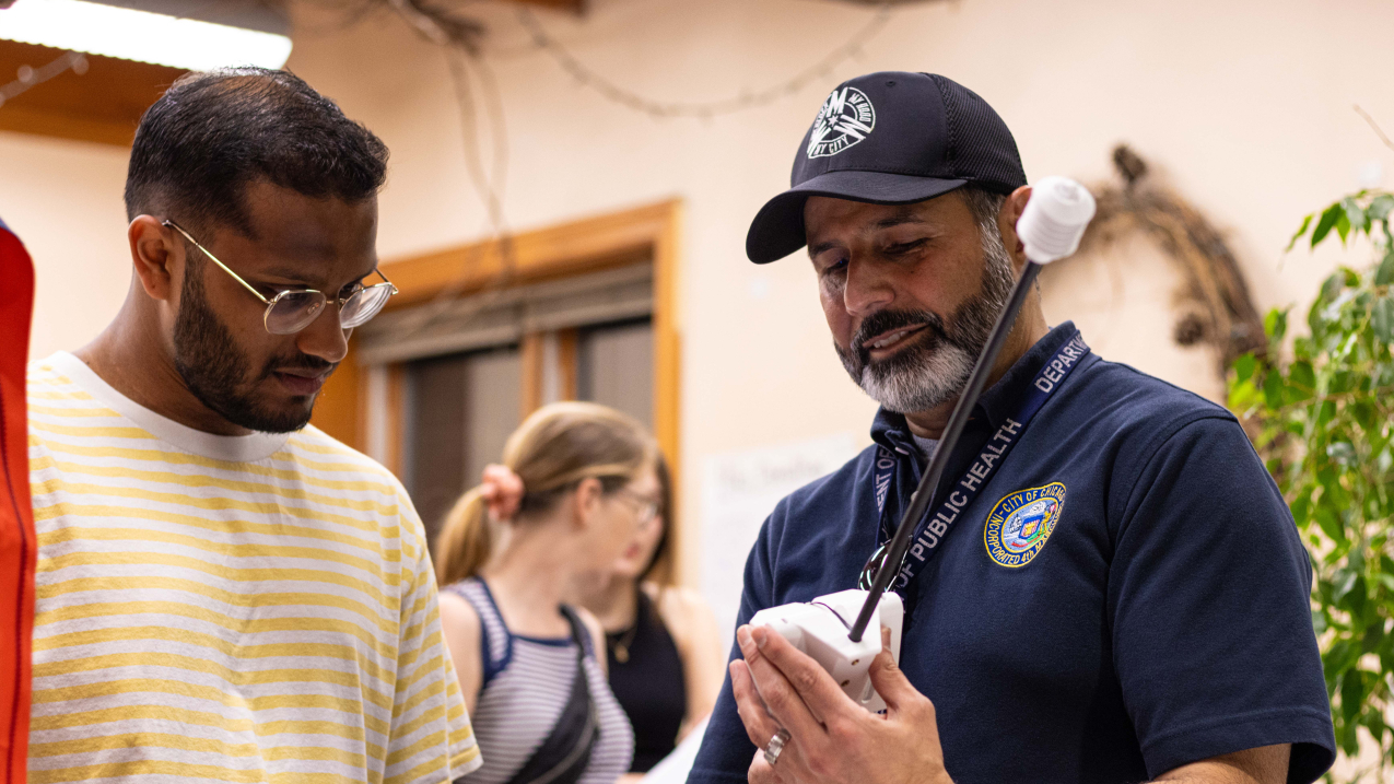 Photo of Raed Mansour showing Ashwin Sunderraj how to use a heat sensor for Chicago’s July 28, 2023 urban heat island mapping campaign (Image credit: 2023 Chicago Urban Heat Island Mapping Campaign)