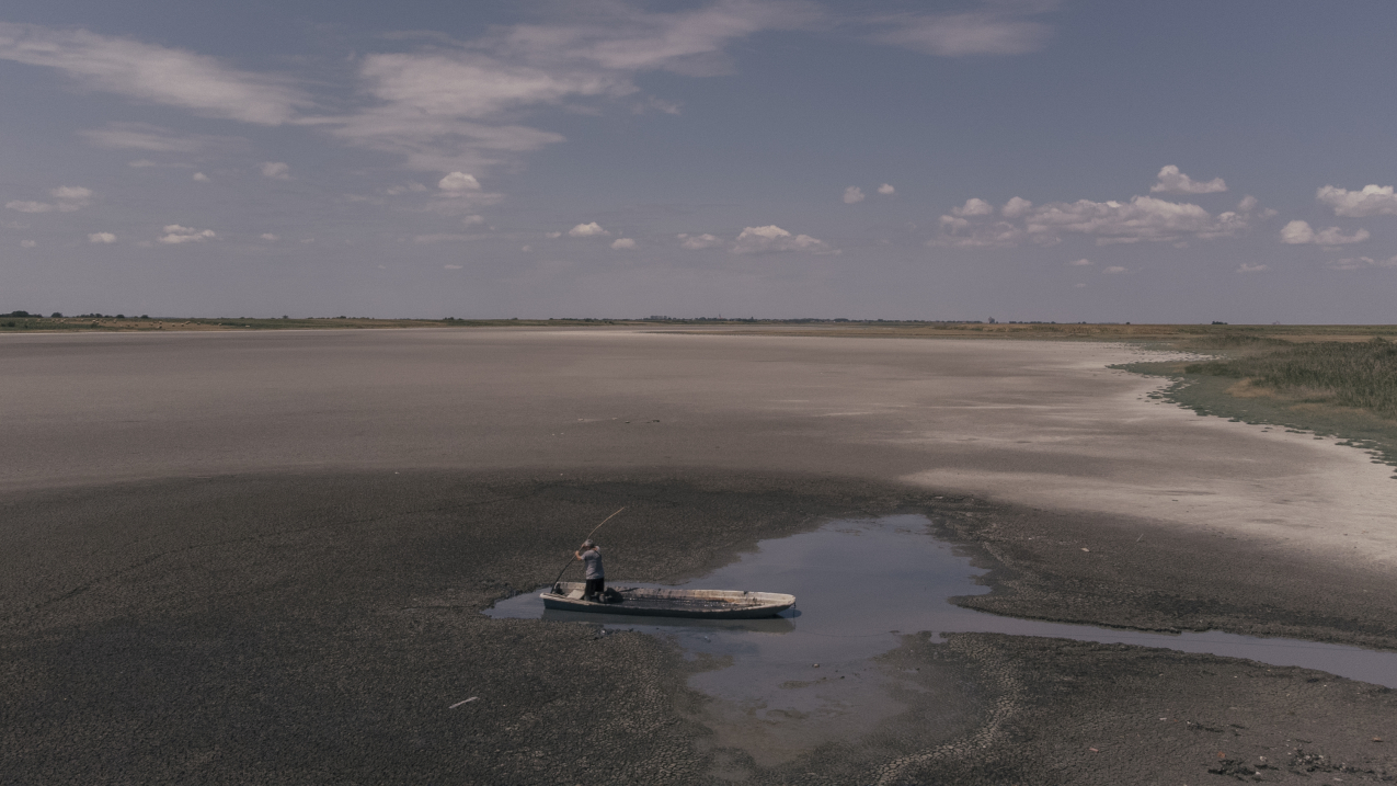 MELENCI, SERBIA - JULY 25, 2024: A worker from a spa collects mud at Lake Rusanda, which dried up for the first time in recorded history during a prolonged heatwave.