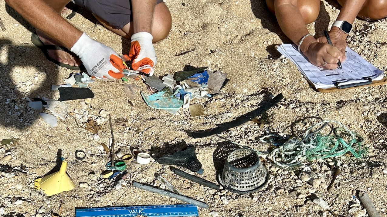 Photo of public participants in NOAA’s Marine Debris Monitoring and Assessment Project sort debris items and record data at Nukoli’i Beach, Hawaii. June 2024 (Credit: Kauai Surfrider)