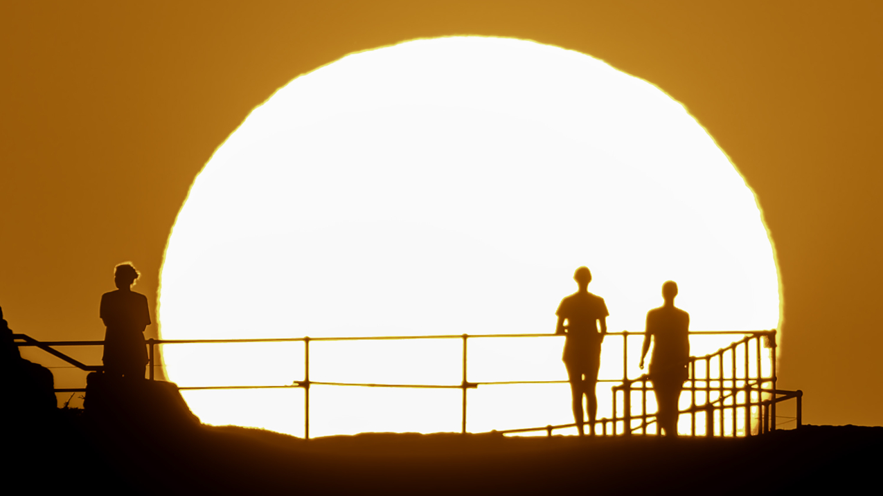 November 27, 2024: People watch as the sun rises over Ben Buckler Point in Sydney, Australia, during a severe November heatwave. Some locations around the state of New South Wales, Australia, saw high temperatures in the mid-to-upper 90s that week. Regionally, Oceania had its second-warmest November on record.