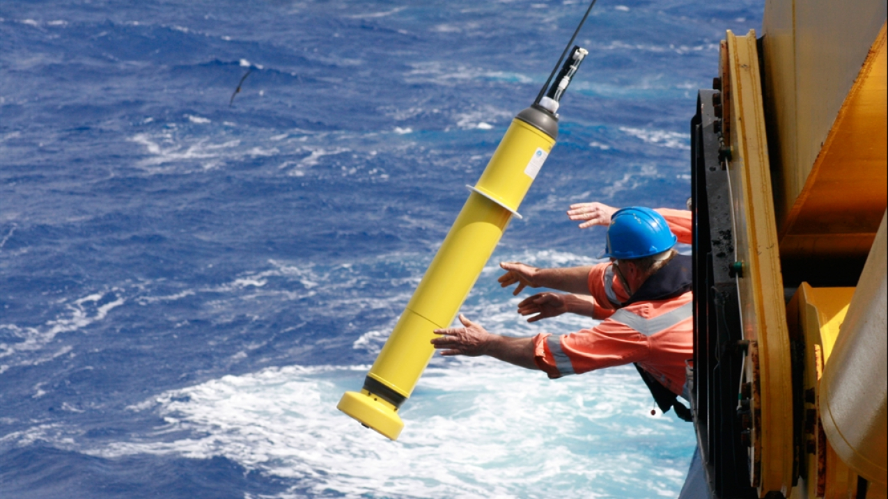Researchers deploy an Argo float into the sea to gather data throughout the water column. 