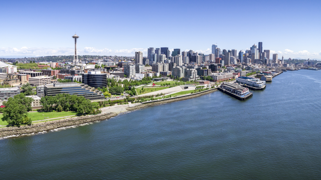 Aerial drone perspective with birds eye view on Elliot Bay with Puget Sound ocean water and city skyline of downtown skyscraper buildings in Pacific Northwest.