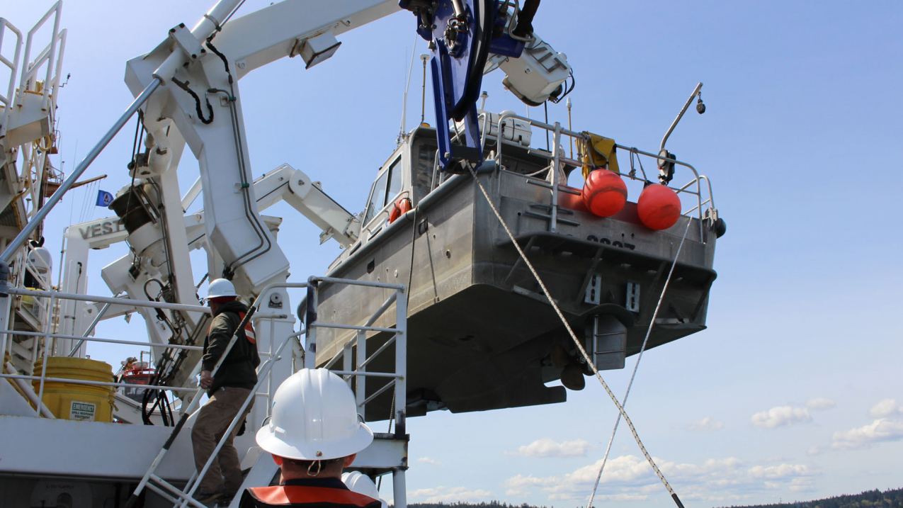 The crew of NOAA Ship Fairweather crew lower a launch into Puget Sound, Washington, for Hydrographic Systems Readiness Review testing. Since 2015, scientists have been gathering data on the Queen Charlotte-Fairweather fault system, a 746-mile long strike-slip fault line that extends from offshore of Vancouver Island, Canada, to the Fairweather Range of southeast Alaska. The team has gathered high resolution bathymetric data through multibeam sonar across 5,792 square miles of the ocean bottom