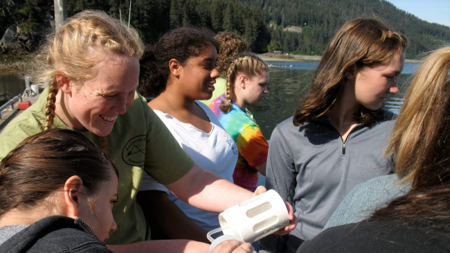 Kaitlin assists several high school students empty a plankton sampling net into a sampling container.