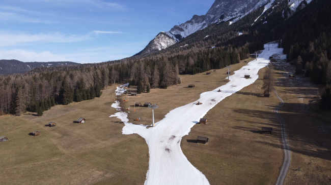An aerial view shows a closed slope of artificial snow below Zugspitze mountain on January 16, 2023, near Ehrwald, Austria.