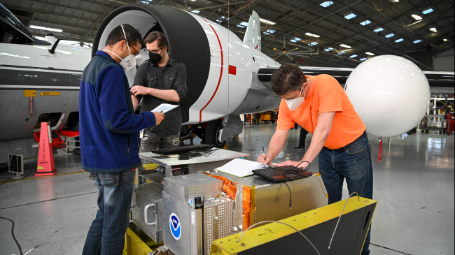 Scientists Rudra Pokhrel, Sam Taylor, and Joshua Schwarz check NOAA instruments during preparations for SABRE mission flights on February 11, 2023. Pokhrel and Taylor are CIRES scientists working with Schwarz in NOAA's Chemical Sciences Laboratory. 