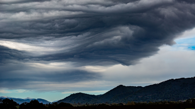 Photo showing the 11th atmospheric river storm moves into Santa Barbara County creating wave and lenticular clouds over the mountains of the Santa Ynez Valley as viewed on March 14, 2023, near Santa Ynez, California. Getty Images.