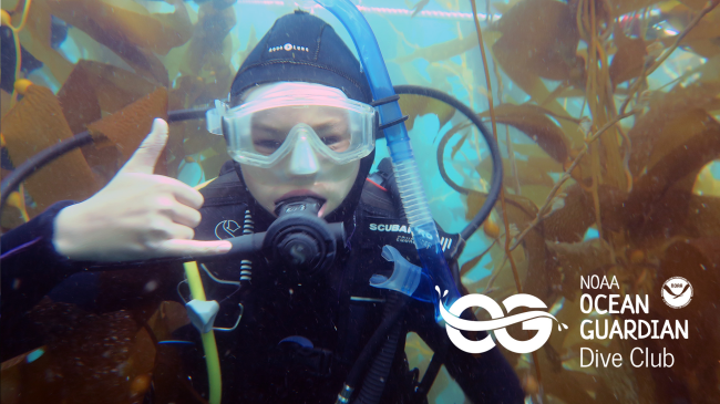 a child wearing full scuba gear underwater and giving a hang loose hand gesture
