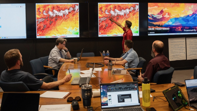 Kyle Thiem, with NOAA’s Global Systems Laboratory, highlights a high wind event in an upcoming simulation at the start of the final day of evaluating two new wildland fire decision support tools on large computer monitors in NOAA’s new Fire Weather Testbed