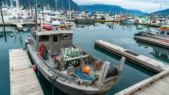 Commercial fishing boats docked at a pier in Whittier, Alaska.