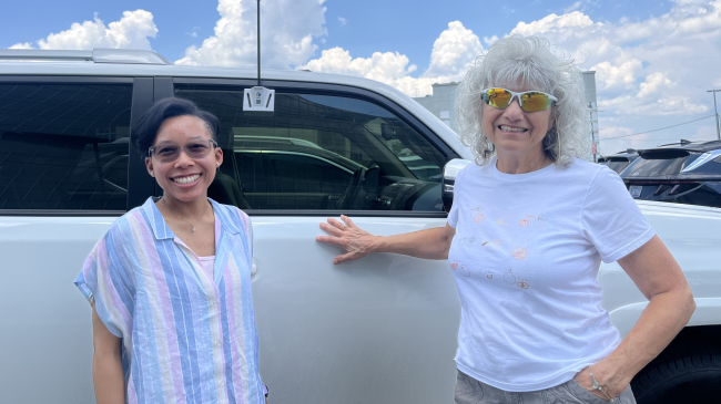 Lindsay Outlaw and Kris Solow stand next to a car equipped with a heat sensor at the urban heat island mapping campaign in Charlotte, North Carolina on July 14, 2024.