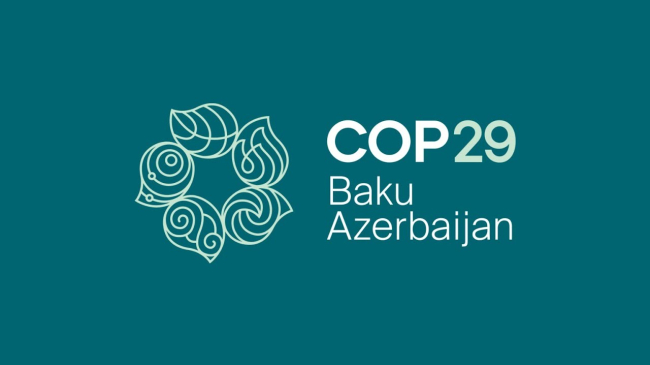 COP29 official logo white text and wreath made of leaves on teal background. Credit: UN Climate Change Conference..