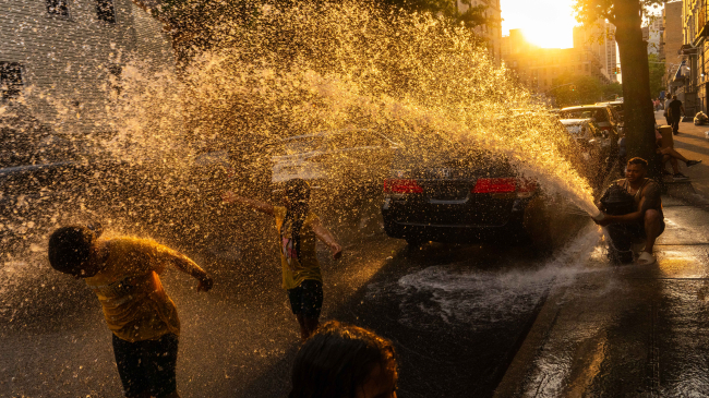  People cool off and play in water sprayed from a fire hydrant during hot weather in the Washington Heights neighborhood of New York City. New York state — and the continental U.S. —  had their warmest year on record in 2024. 