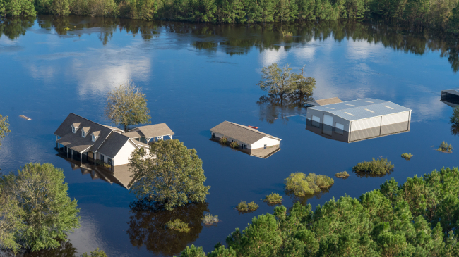 Bladen County, NC., September 18, 2018 -- An aerial photo of a house and nearby buildings in a wooded area heavily flooded from Hurricane Florence. (Photo posted on fema.gov.)