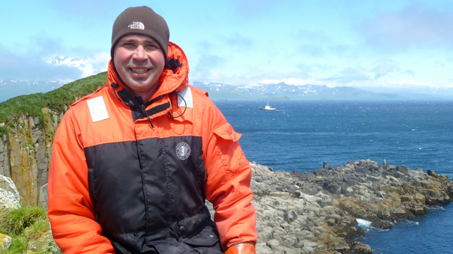 Dr. Jeremy Sterling takes a rest on island cliffs during a survey.