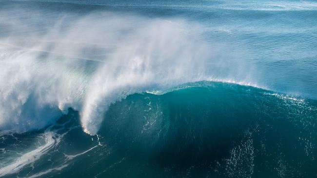 A wave cresting in the open ocean.
