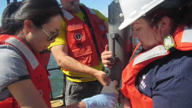 Yuan Liu, a biologist with the NOAA Fisheries Milford Lab in Connecticut, collects water samples. 