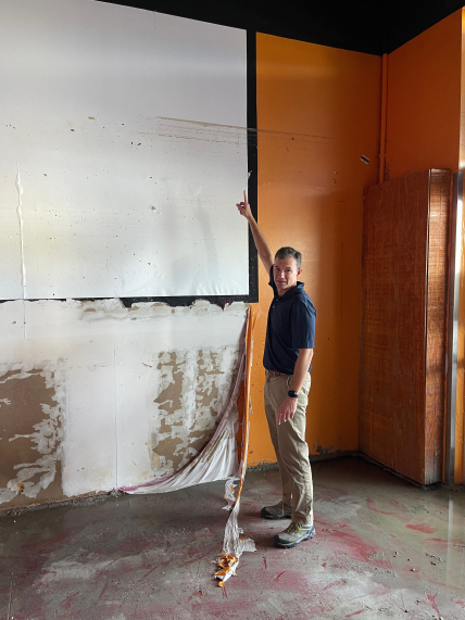 NHC Deputy Director Jamie Rhome pointing at the storm surge water marks from Hurricane Ian in 2022. 
