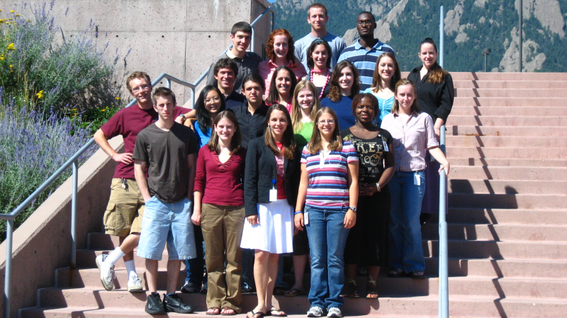 A group of people pose outside on a staircase